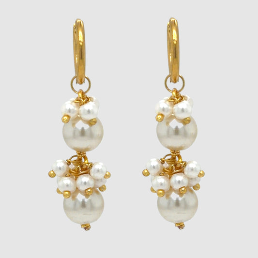 Delicate gold hoop earrings with dangling freshwater pearl cluster charms
