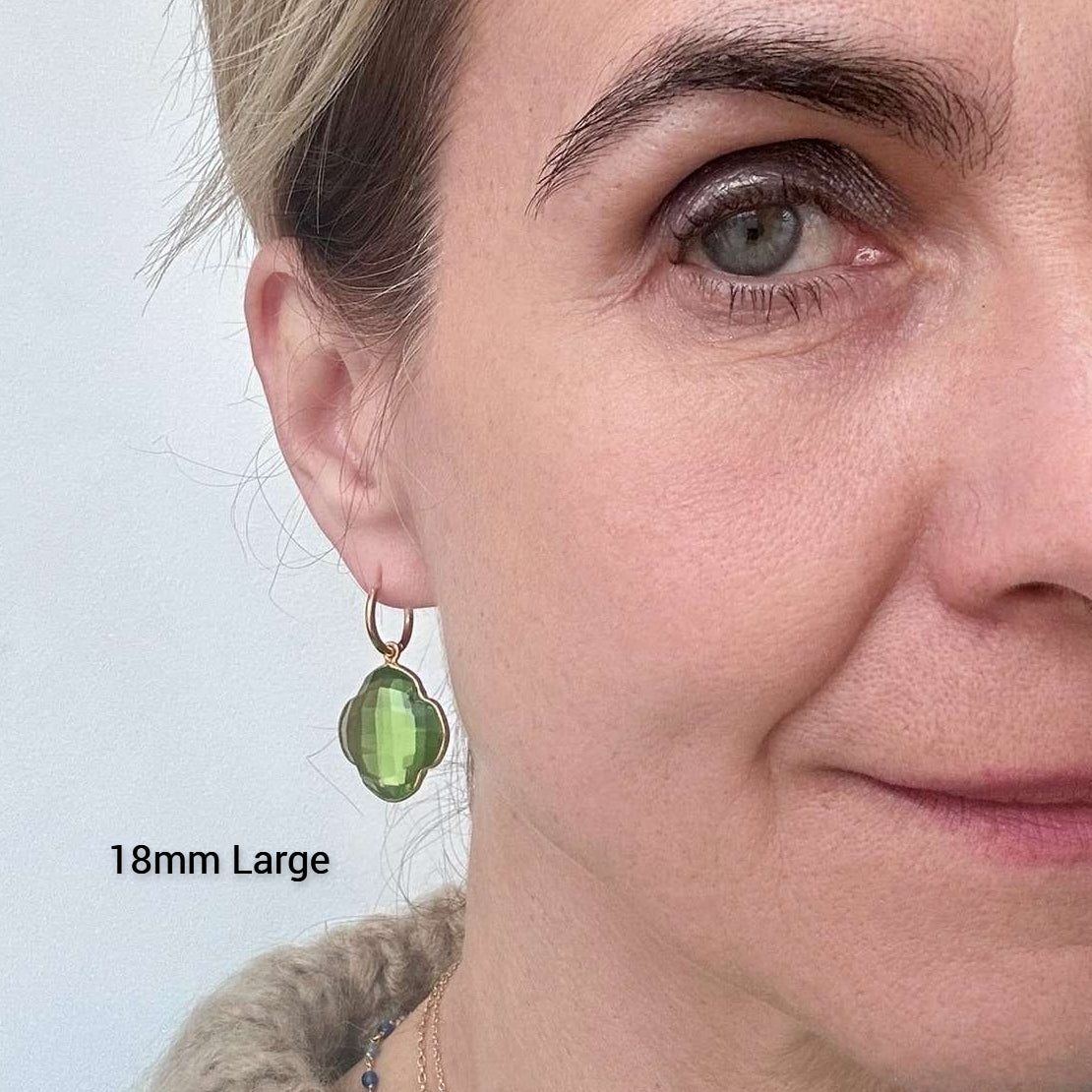 Delicate gold hoop earrings with peridot semi-precious gemstone clover shaped charms 