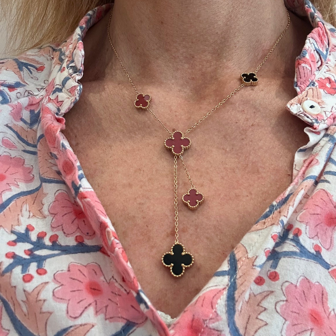 Lariat necklace with five small and medium sized reversible clover charms in black and red