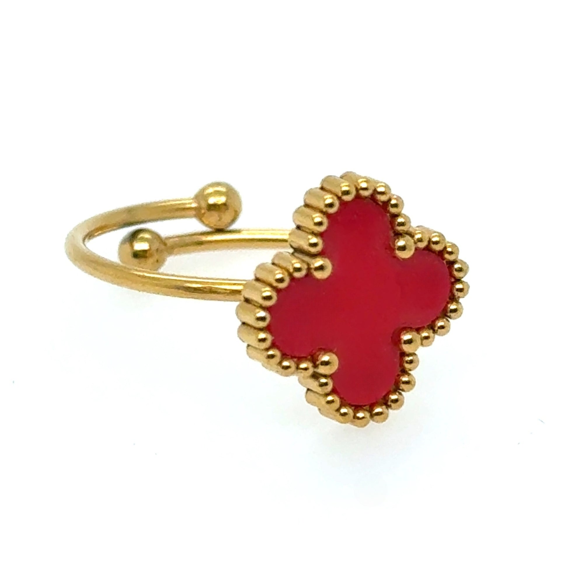 Gold ring with a red heart-shaped stone on a white background