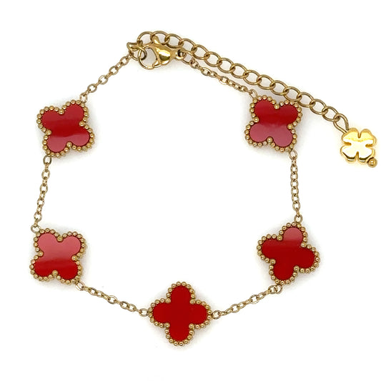 gold bracelet has five small clover charms in red enamel