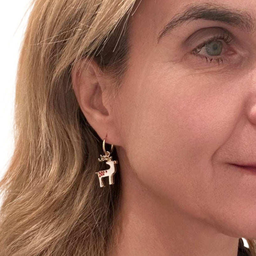 Woman wearring earrings with reindeer charm
