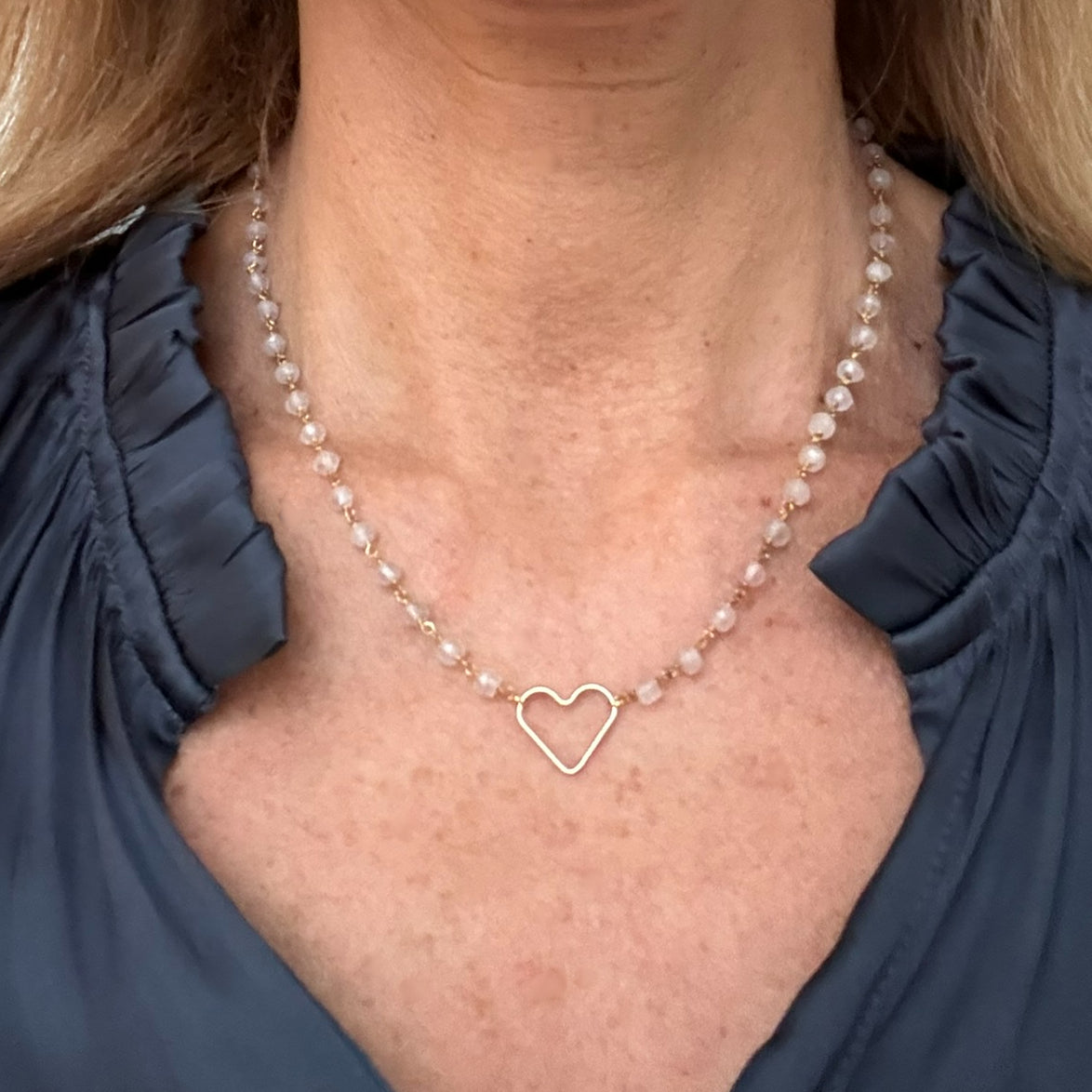 Lovely Rose Quartz rosary chain necklace with delicate heart charm in the middle worn on model