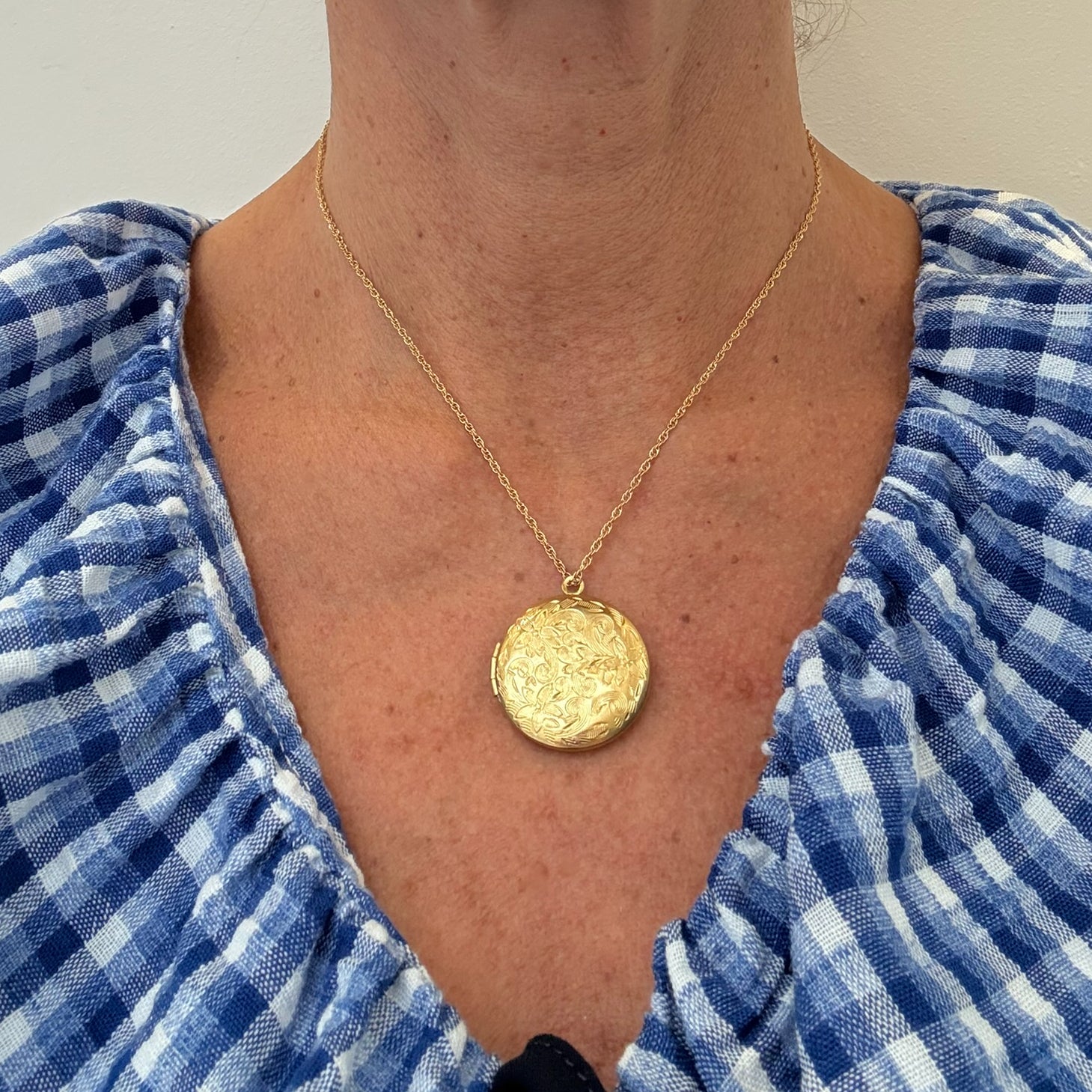 twisted belcher chain necklace with round locket with a lovely floral engraving worn on model