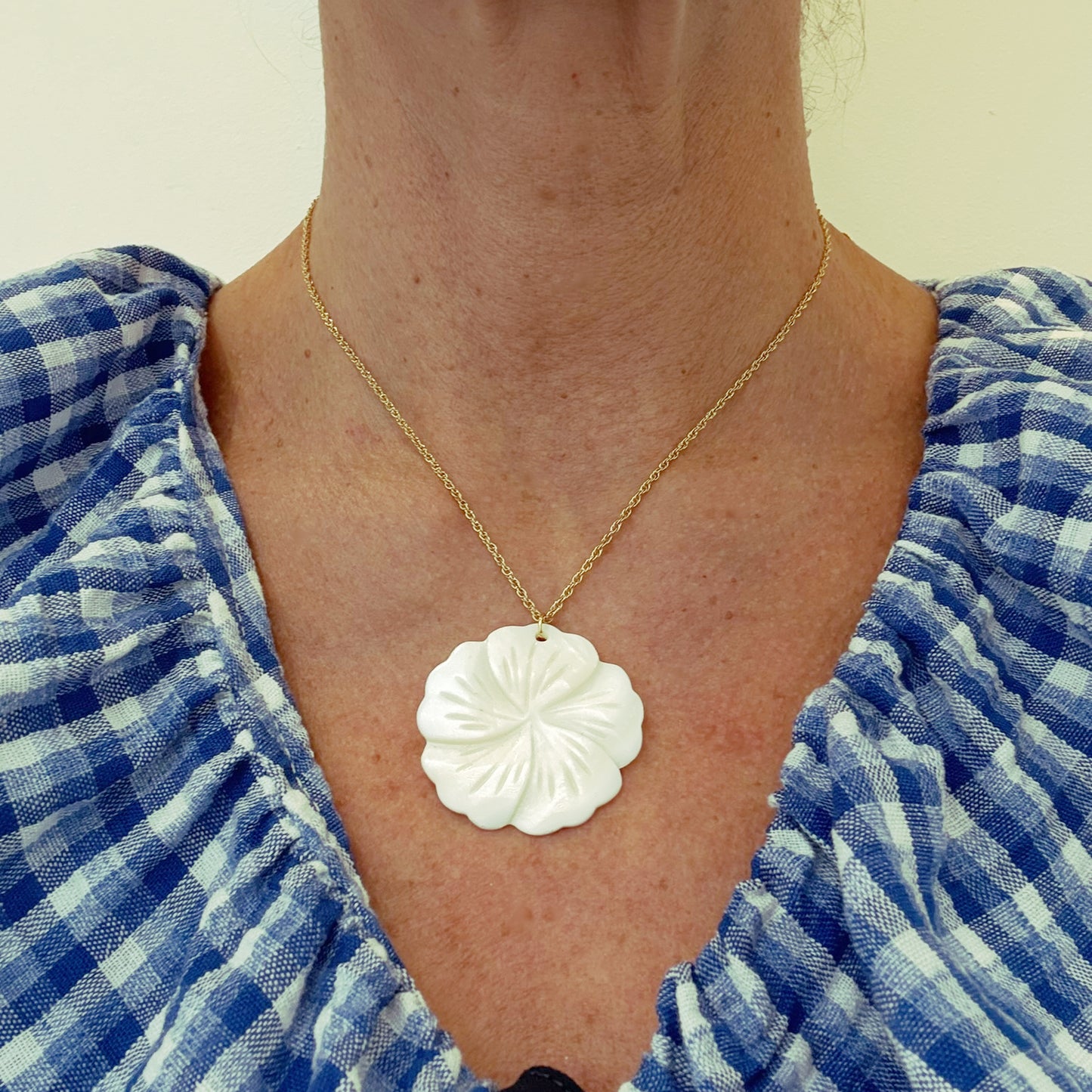 twisted belcher chain necklace with smooth mother of pearl flower shaped pendant worn on model
