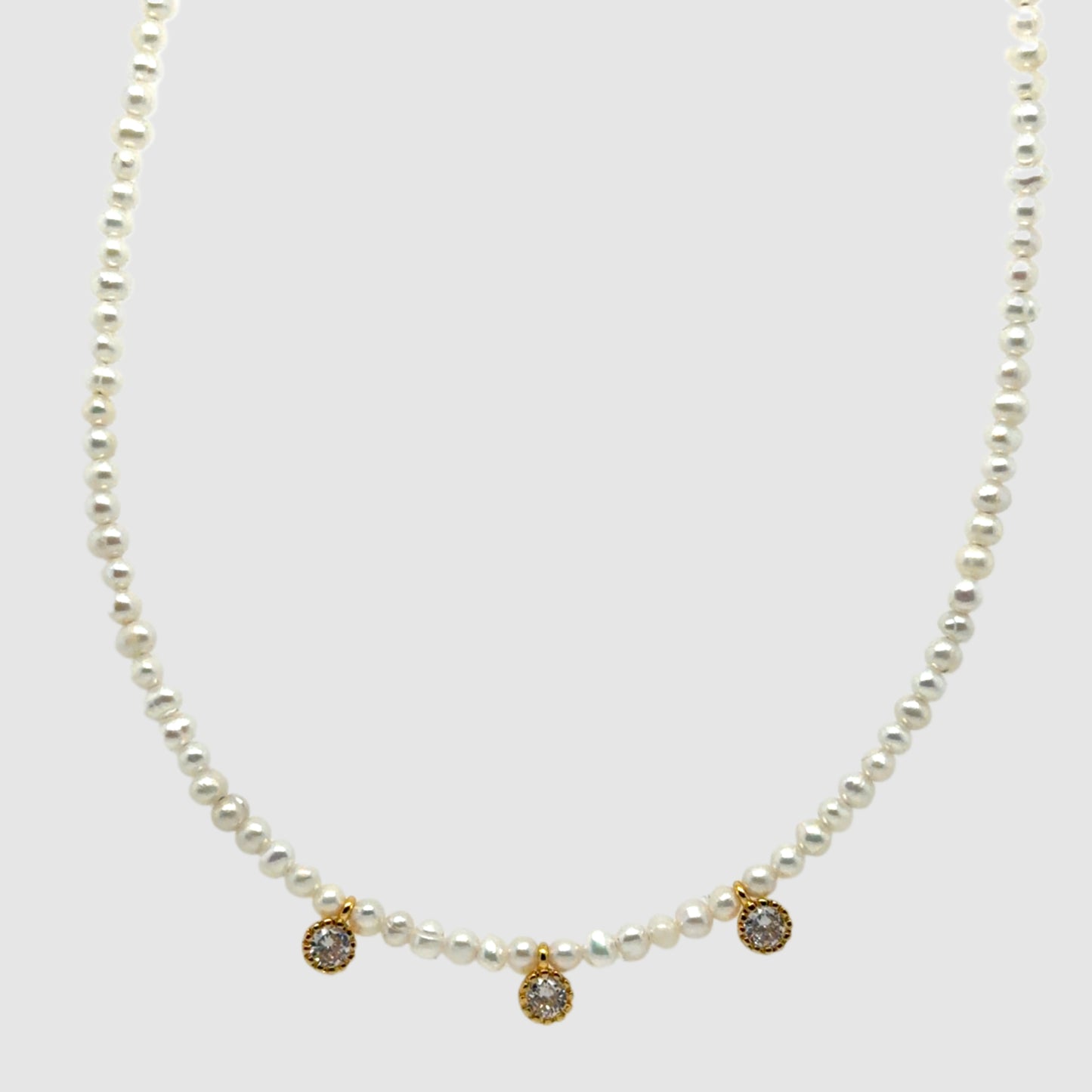 Elegant necklace with small Freshwater pearl beads and three small sparkly charms in the middle
