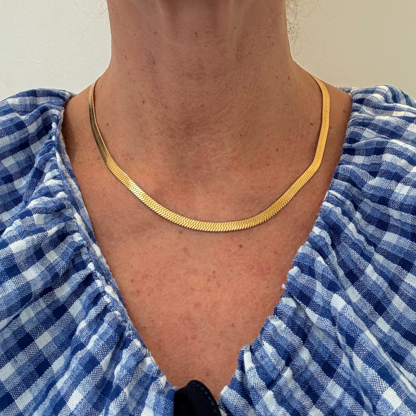 model wearing smooth 'snake' gold necklace