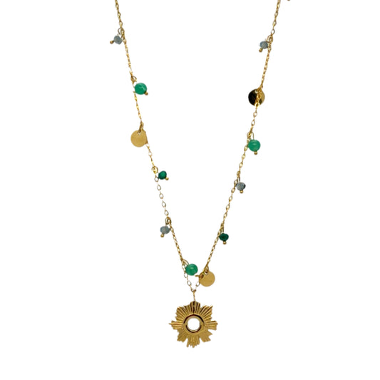 A gold-toned necklace featuring a central sunburst pendant, small gold discs, green beads, and blue beads on a white background.