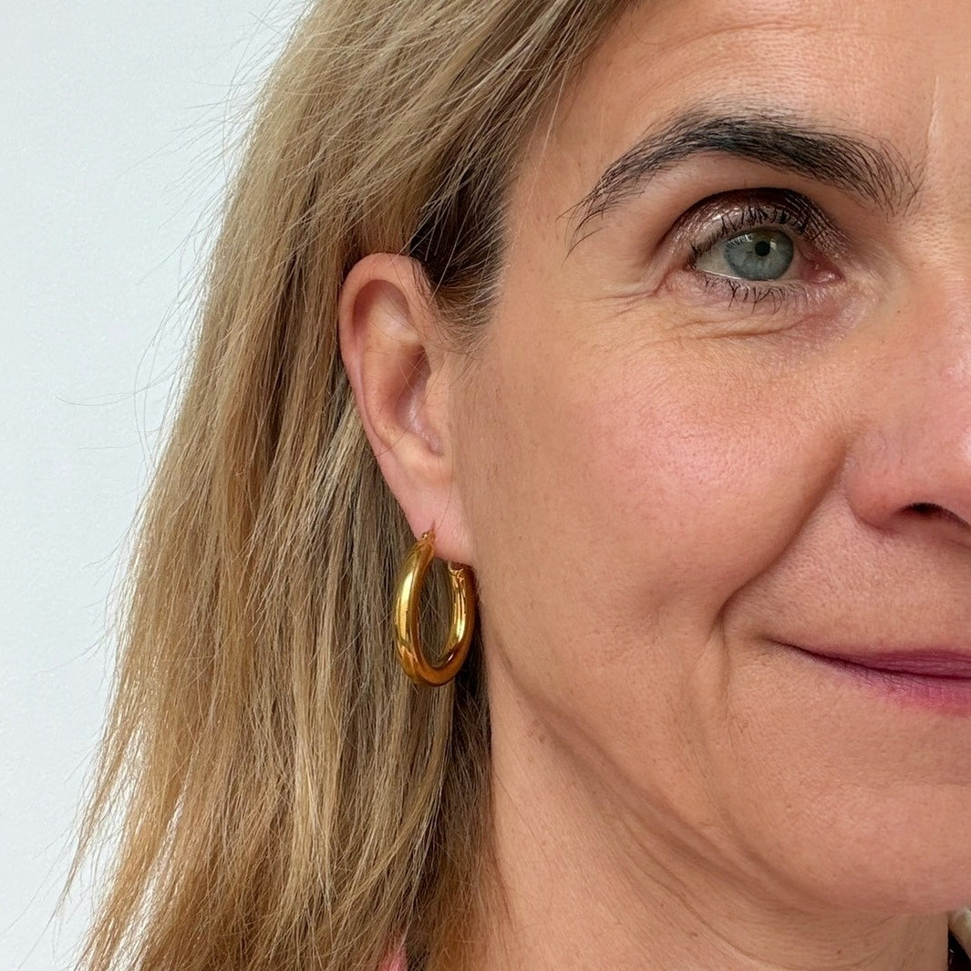 woman wearing 30mm gold hoop earrings