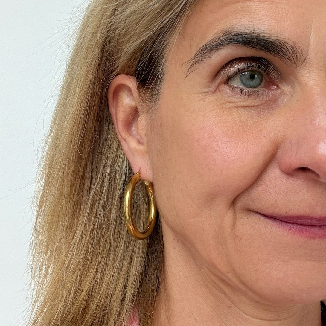 woman wearing 40mm gold hoop earrings