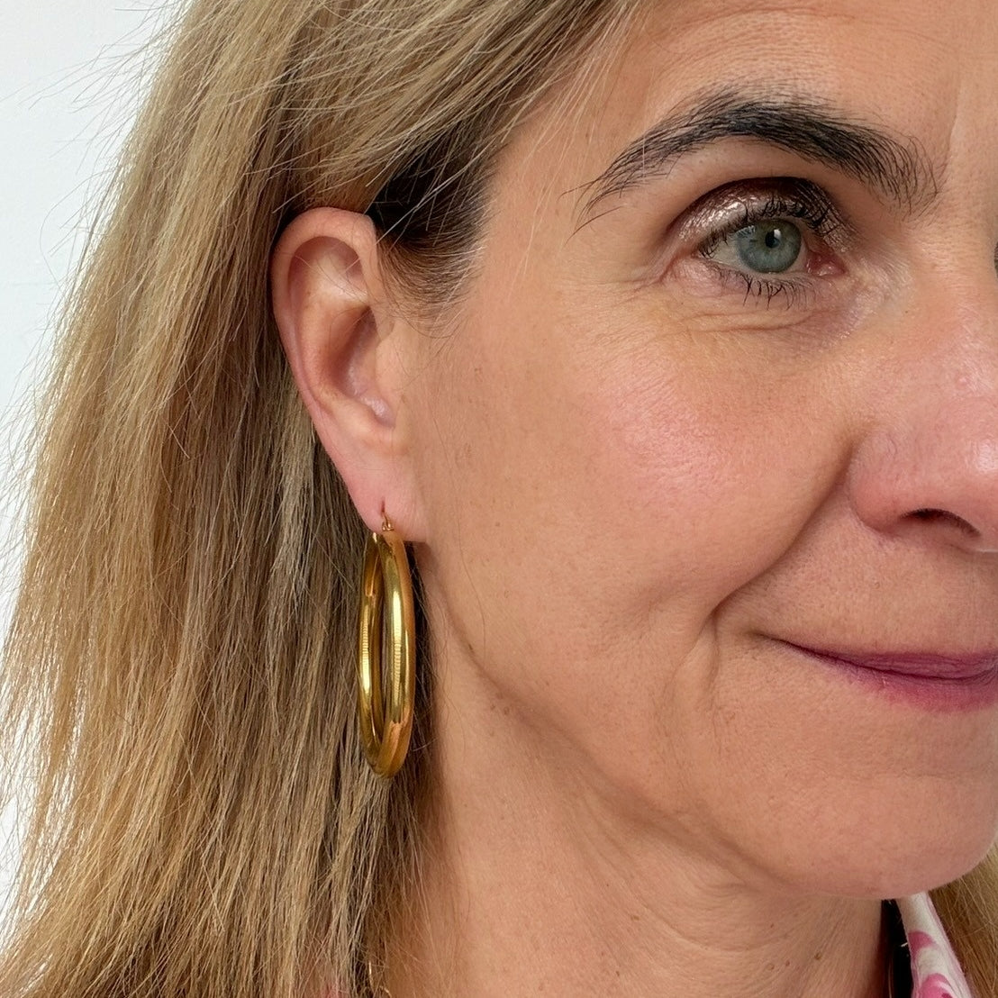 woman wearing 50mm gold hoop earrings