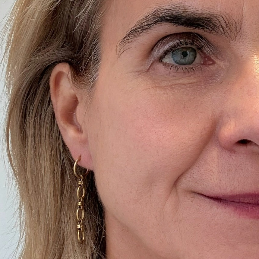 Gold hoops with dangling charm made from 2 or 3 links of a lovely oval chain worn on model