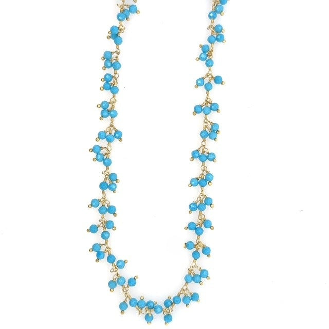 Gold necklace with bright turquoise gemstone beads arranged in clusters