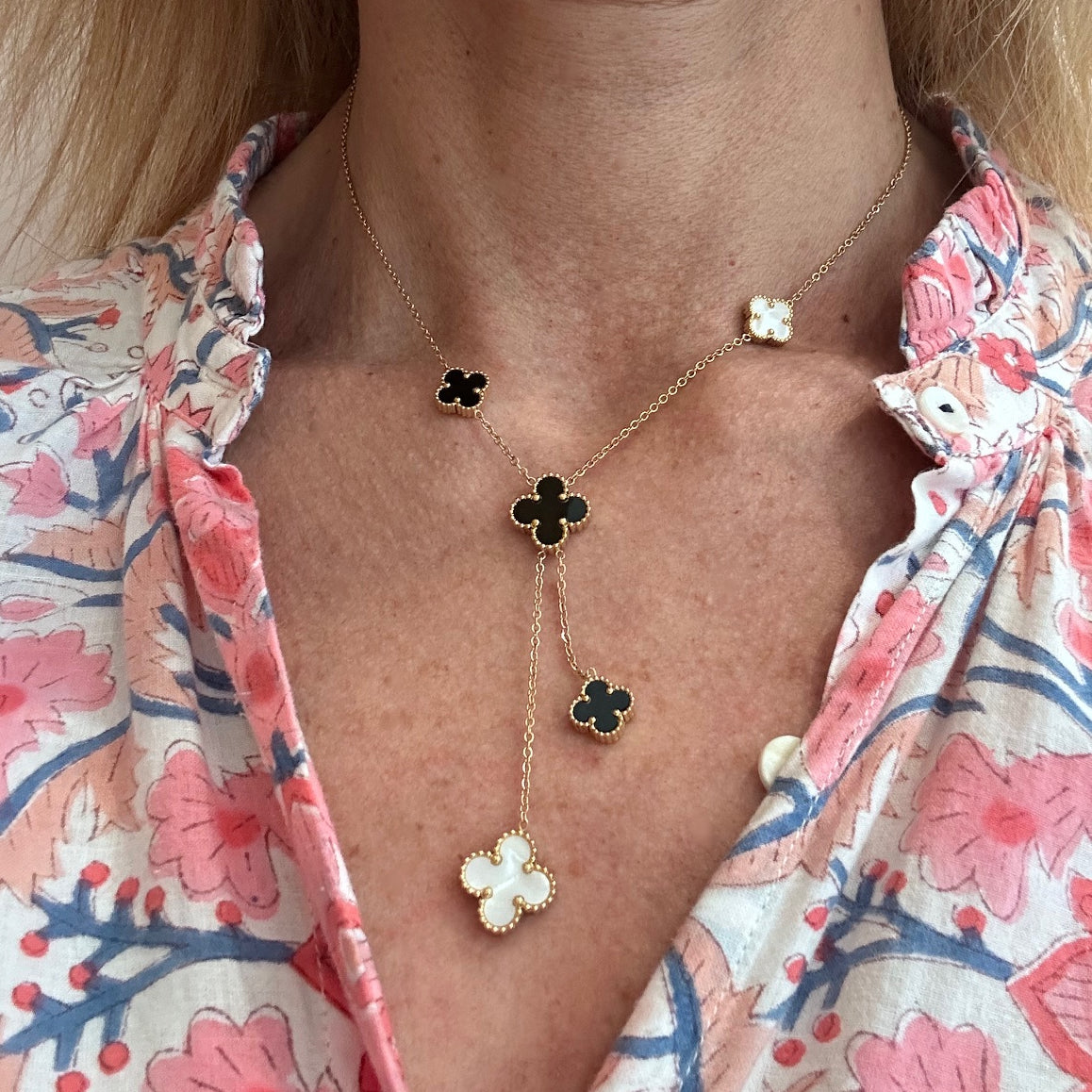 Lariat necklace with five small and medium sized reversible clover charms in black and white