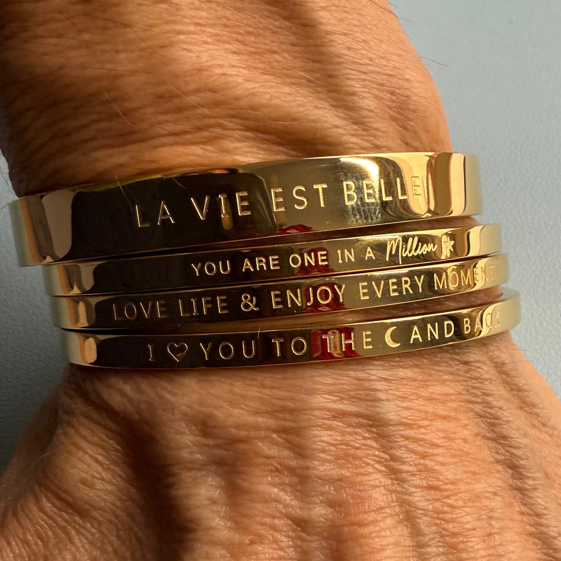 Gold bangles for the wrist which 
 have fun phrases engraved on them and clip closed