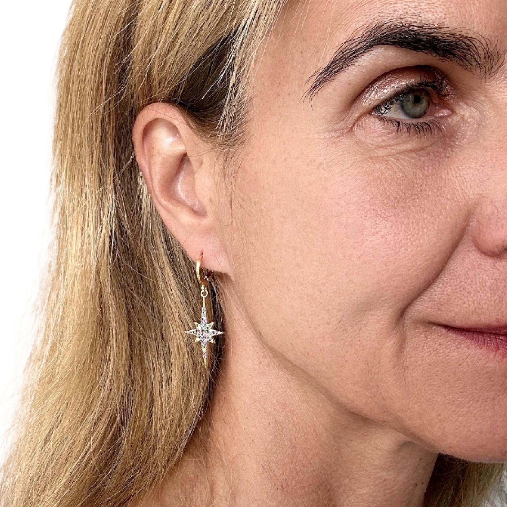 Close-up of a woman wearing star-shaped earrings with a white background
