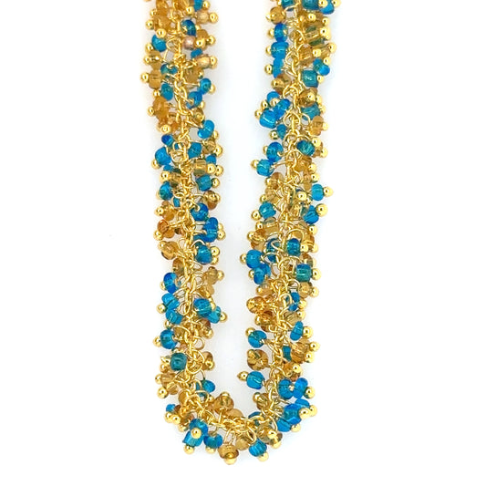 Necklace with blue topaz amd crystal quartz grape styled small charms all around