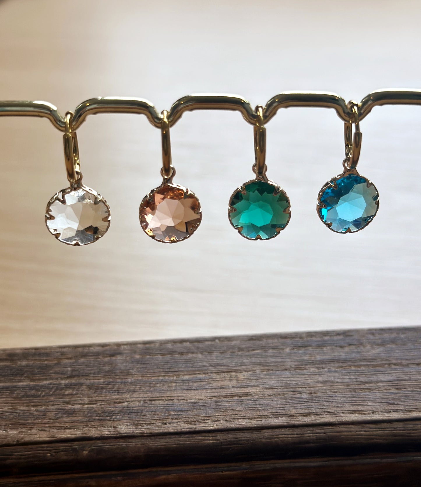 gold hoop earrings with crystal round charms in pink, green, blue and transparent.