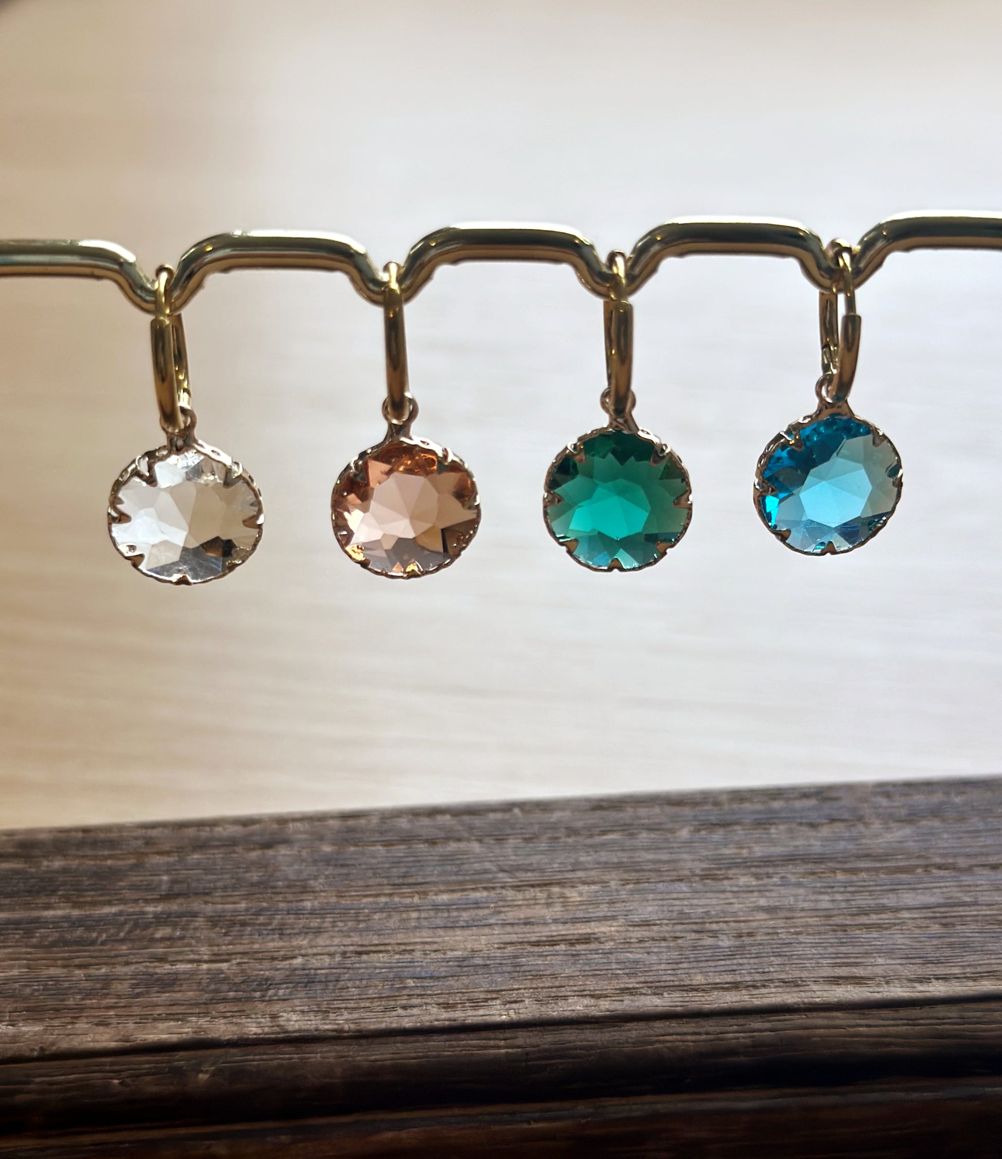 gold hoop earrings with crystal round charms in pink, green, blue and transparent.